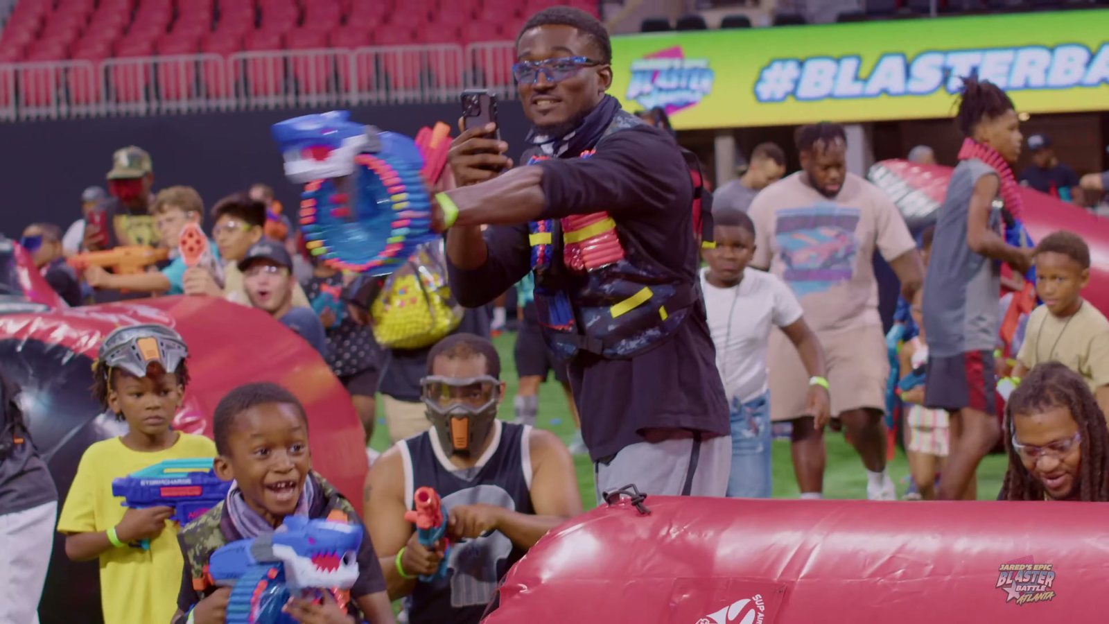 Kids and adults with foam blasters celebrating behind an inflatable bunker