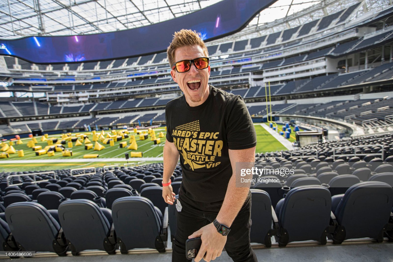 Jared Guynes cheering in the stands at SoFi Stadium, with inflatable bunkers set out on the field behind him