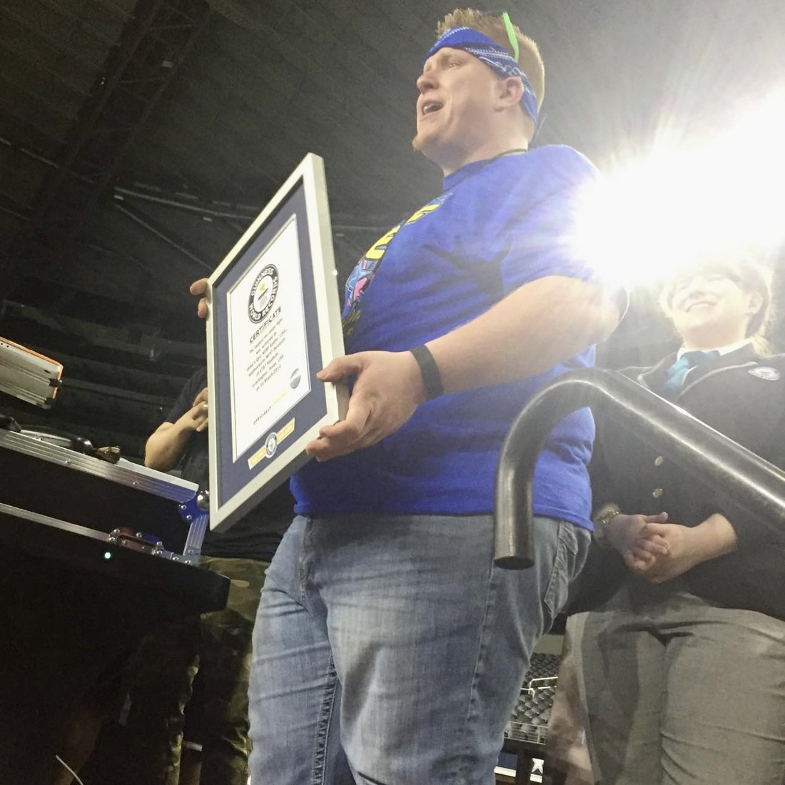 Jared Guynes holding up the Guinness World Records certificate on the field at AT&T Stadium in 2016