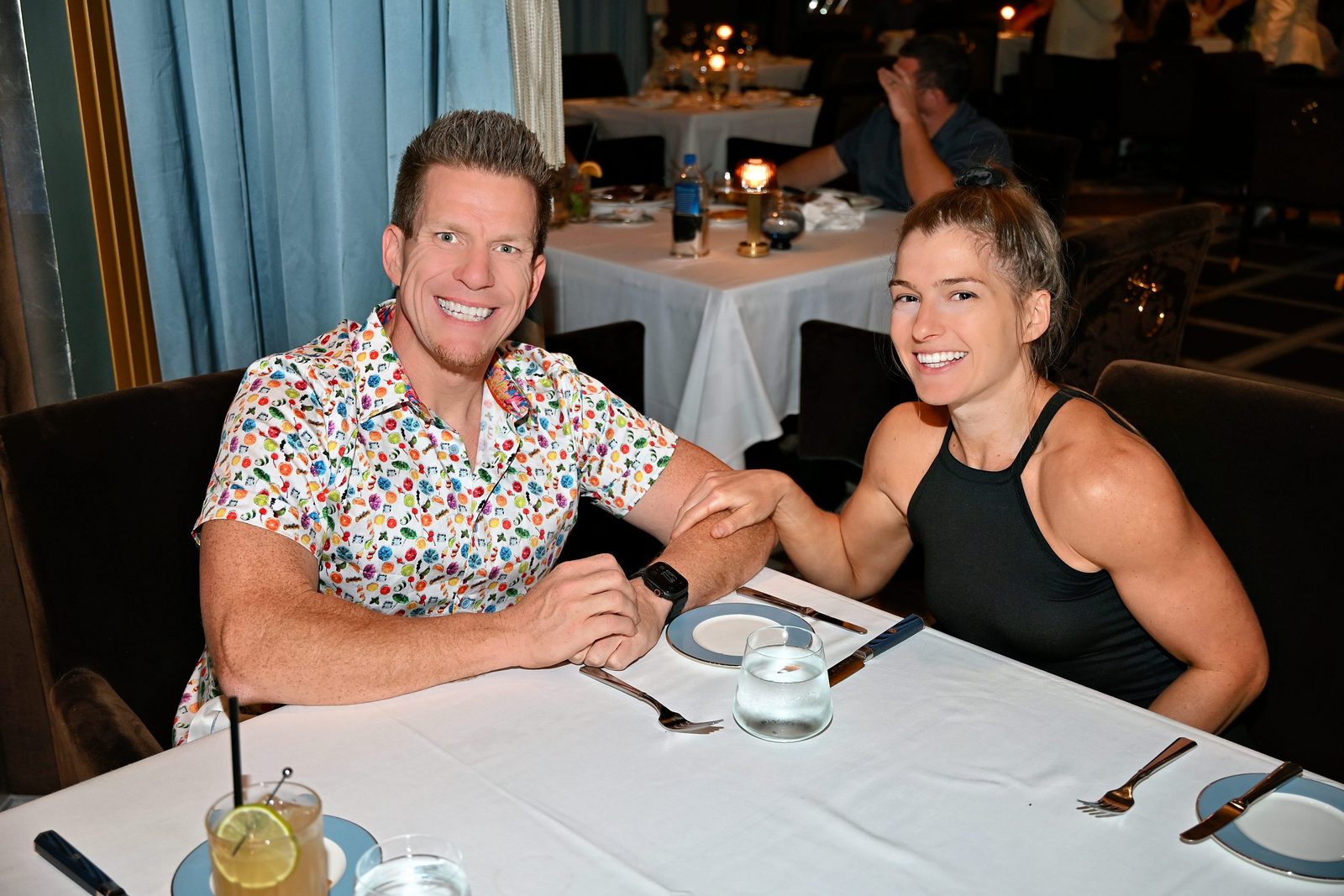Jared Guynes and Jessica smiling together at a restaurant table