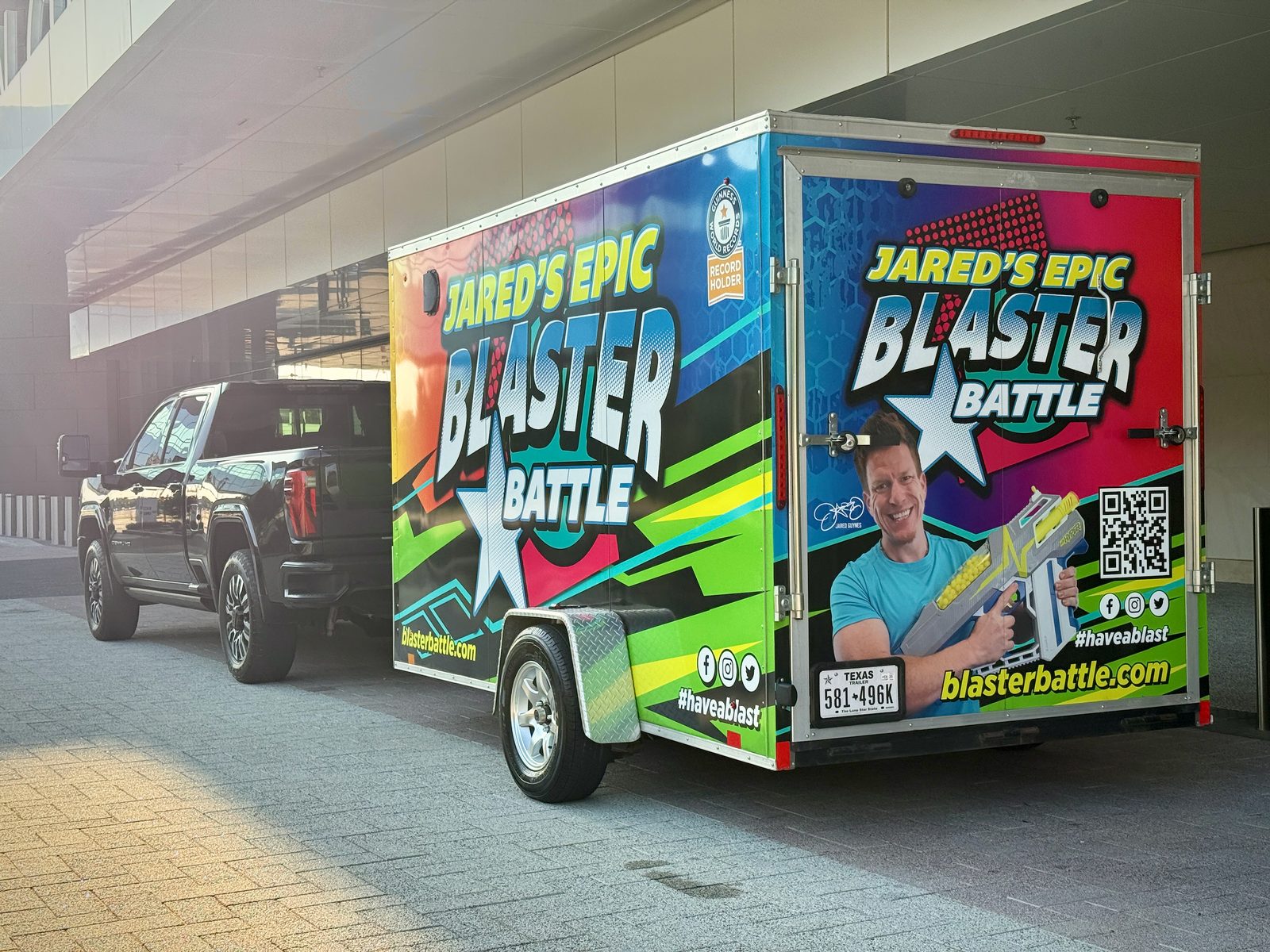 The Jared's Epic Blaster Battle trailer, wrapped with Jared's photo and the event logo, hitched to a pickup truck