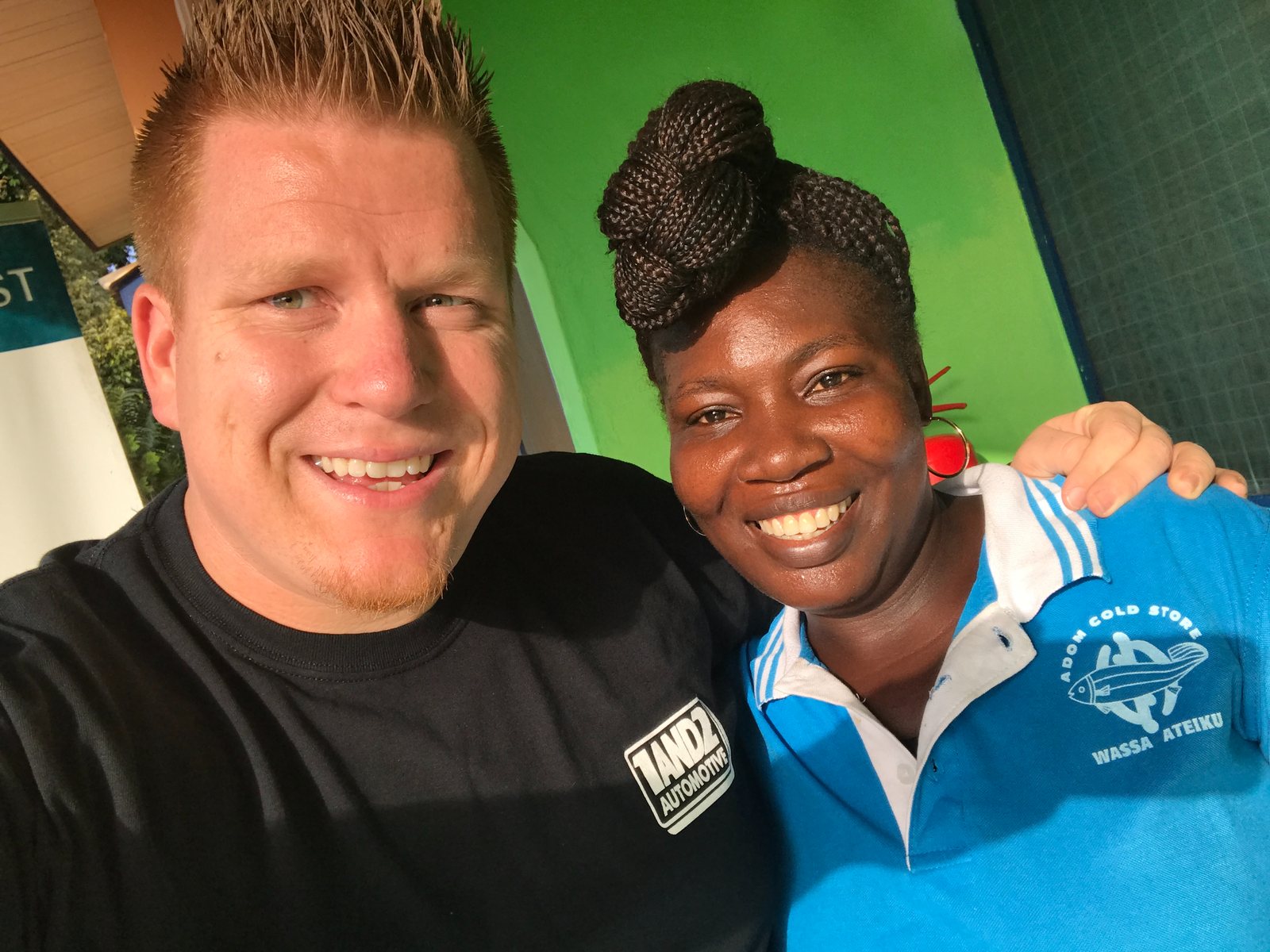 Jared Guynes and a woman in an Ateiku shirt smiling together during his 2016 trip to Ghana