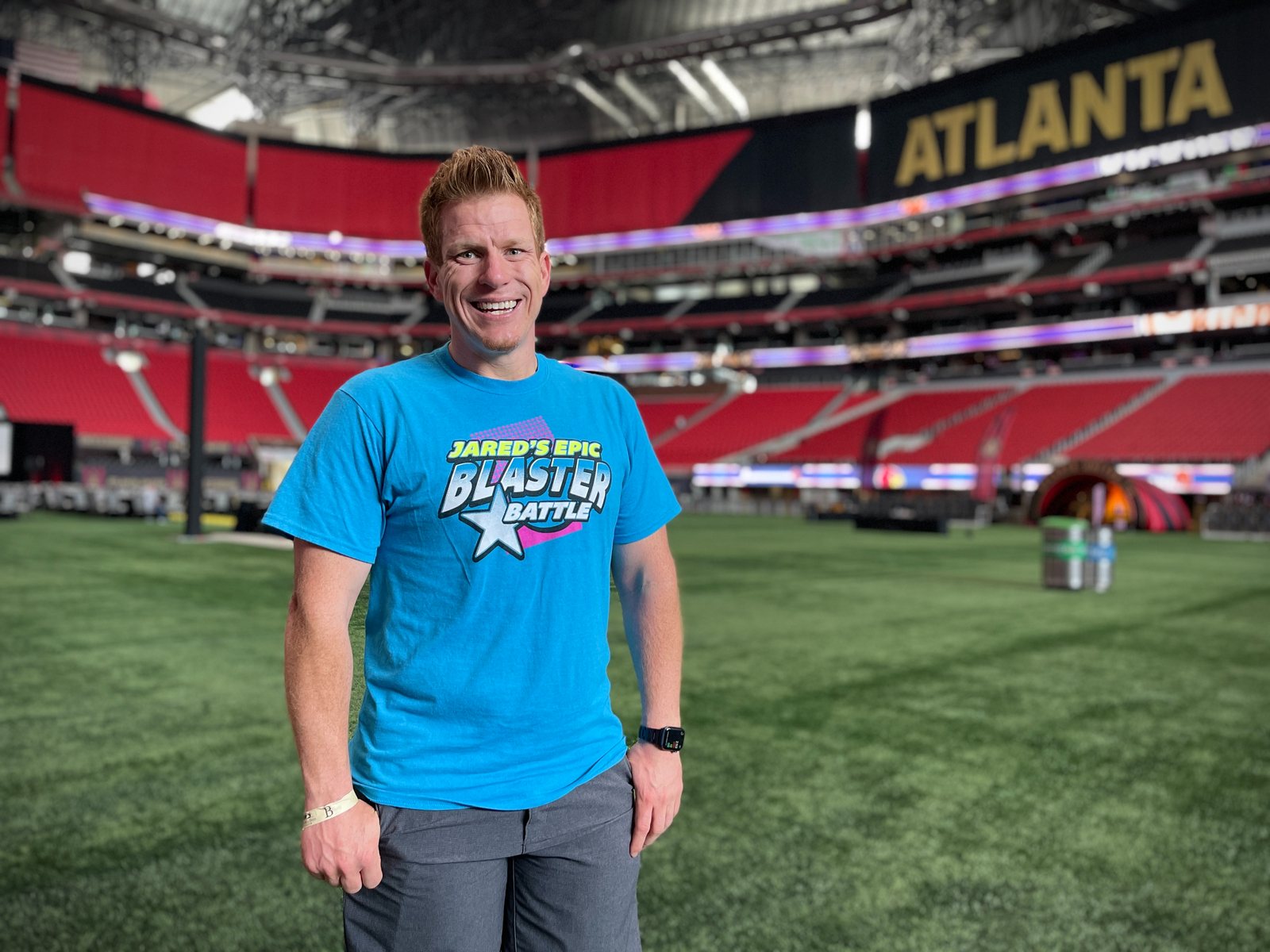 Jared Guynes in a Jared's Epic Blaster Battle shirt on the field at Mercedes-Benz Stadium in Atlanta