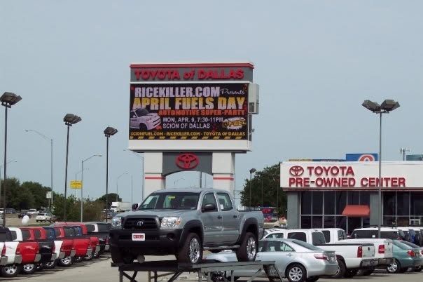 The Toyota of Dallas sign advertising RiceKiller.com's April Fuels Day, with a pickup truck on display below it